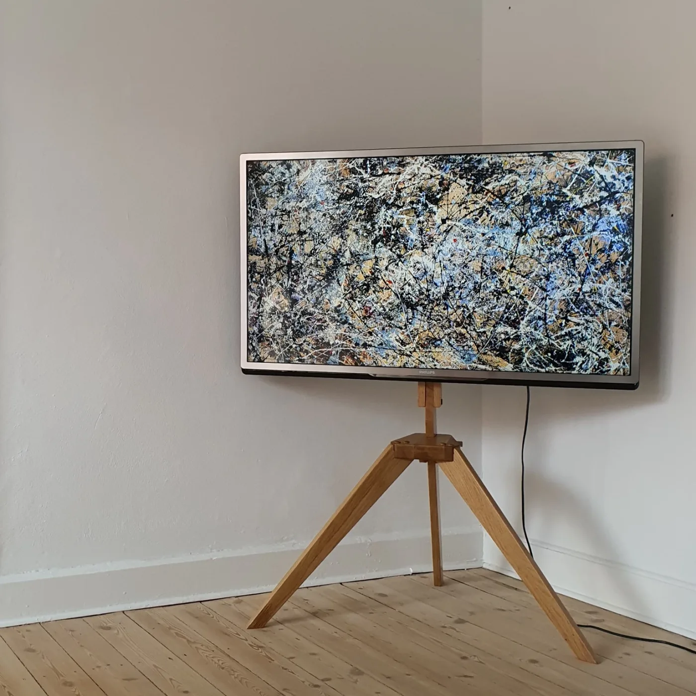 Wooden TV stand prototype holding a Philips TV in a room corner